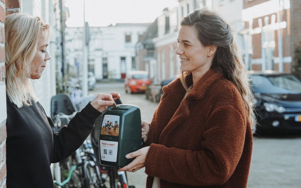 Huis-aan-huiscollecte. Op elke collectebus staat een QR-code, maar de meeste mensen geven nog contant geld. beeld ZOA, Lieuwe Siebe de Jong