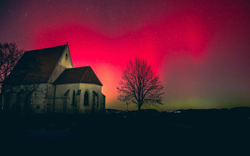 Oud kerkgebouw met een rood-groene lucht.