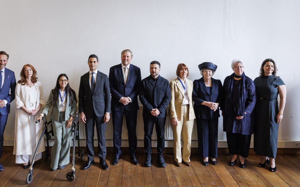 Groepsfoto met vier mannen en zes vrouwen op een rij.
