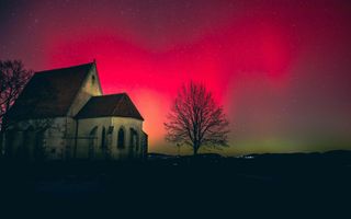 Oud kerkgebouw met een rood-groene lucht.
