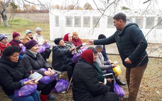Een man deelt bijbels uit aan bezoekers van een openluchtsamenkomst in Oekraïne.