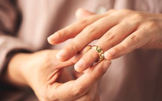 Vrouw schuift een trouwring van haar vinger.