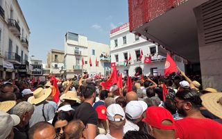 Menigte zwaait met vlaggen.