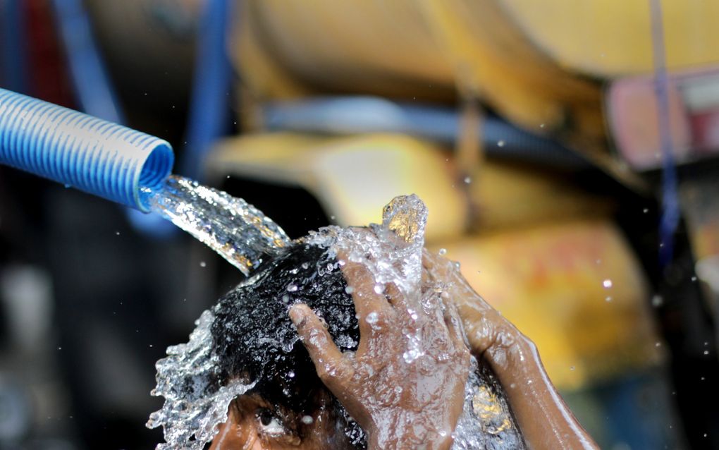 Zondag was de warmste dag ooit geregistreerd. Foto: een Indiase jongen koelt af met een waterkraan. beeld EPA, Piyal Adhikary 