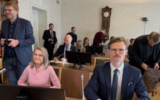 vrouw in roze kleding en man in blauw pak in rechtszaal