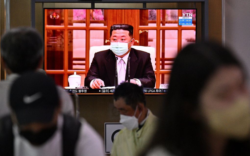 Kim Jong Un met mondkapje is te zien op televisieschermen. Beeld AFP, Anthony WALLACE