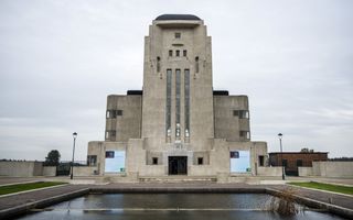 Groot, stenen gebouw met een vijver ervoor. 