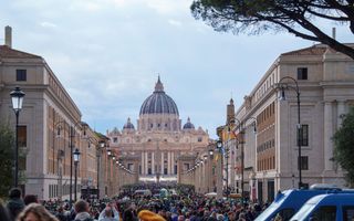 Rijen wachtende mensen voor de koepelvormige Sint-Pieterskerk in Rome