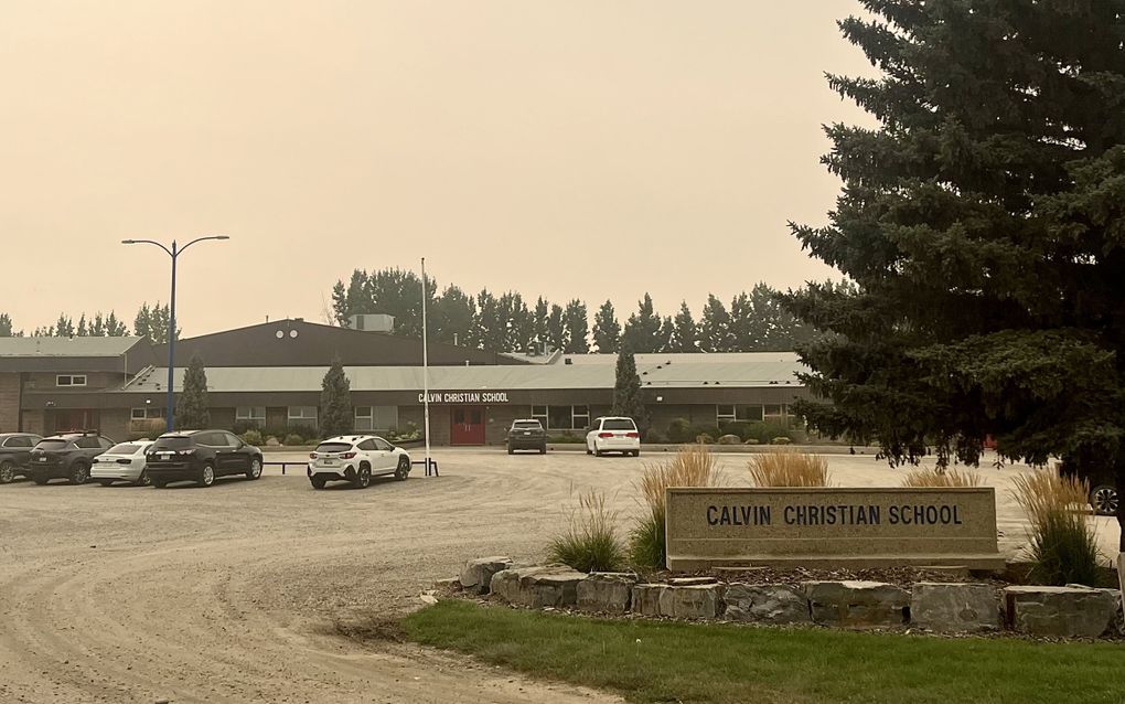 Schoolgebouw met auto’s ervoor.