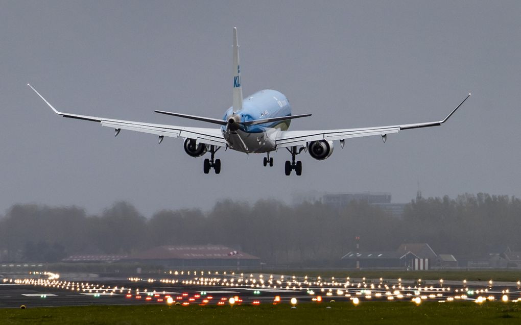Een toestel van KLM landt bij avond op de Polderbaan van luchthaven Schiphol.