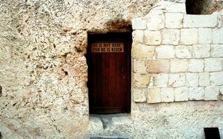 De graftuin met het graf van Jezus. Op de deur staat ”Hij is hier niet; want Hij is opgestaan”. beeld Sjaak Verboom