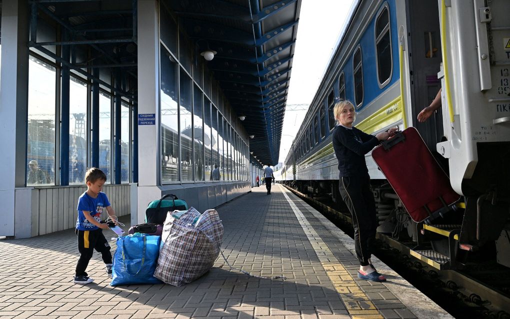 Een vrouw en haar kind komen aan in Polen, na hun vlucht uit Oekraïne. Beeld AFP, Sergei SUPINSKY