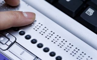 Een vinger voelt aan een toetsenbord met braille