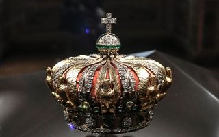 Gouden glimmende kroon bezet met diamanten en een kruis