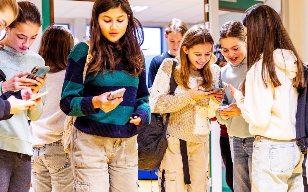 Leerlingen met smartphones in de hand. beeld ANP, Iris van den Broek