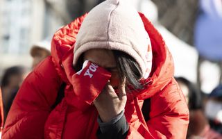 Een vrouw in een rode jas moet huilen. 