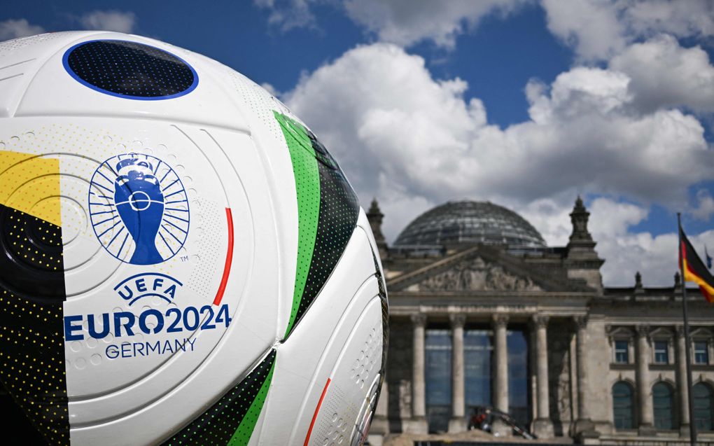 Een reusachtige bal op het plein voor het Rijksdaggebouw in Berlijn wijst op het komende Europees kampioenschap voetbal dat vrijdag van start gaat in Duitsland. beeld AFP, Ralf Hirschberger