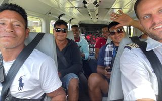 Joop van Weele (rechtsvoor op de foto) met in het vliegtuig deelnemers van de Bijbelschool in Suriname. beeld Joop van Weele