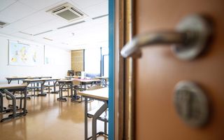 Stoelen en tafels in een klaslokaal.