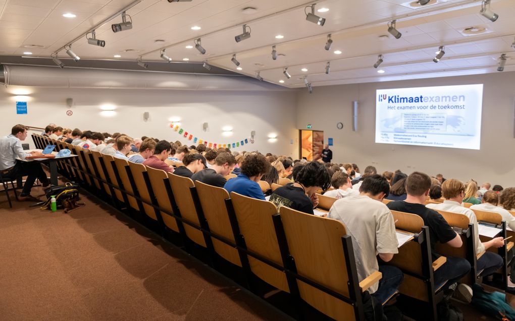 Een diploma hangt er niet van af, toch bogen tientallen studenten en docenten van de Hogeschool Utrecht zich donderdagmiddag over het Klimaatexamen. beeld Caroline Martinot