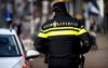 GRONINGEN - Een politieagent in een operationeel uniform op straat naast een politieauto. Politie, surveilleren, patrouille. ANP XTRA KOEN VAN WEEL