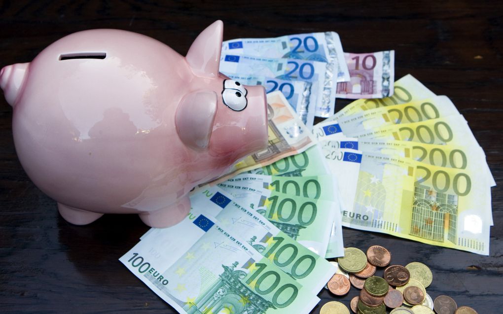 Illustratieve foto van een spaarvarken, eurobiljetten en muntgeld