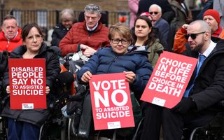 Mensen in rolstoelen met rode borden. 