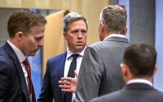 Ernstig kijkende mannen in pakken praten met elkaar 