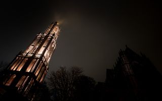 De verlichte Domtoren steekt af tegen de nachtelijke hemel.