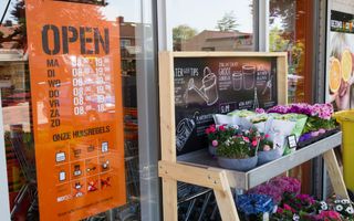 Op de foto is een bord met de openingstijden van een winkel te zien. Deze winkel is op zondag gesloten.
