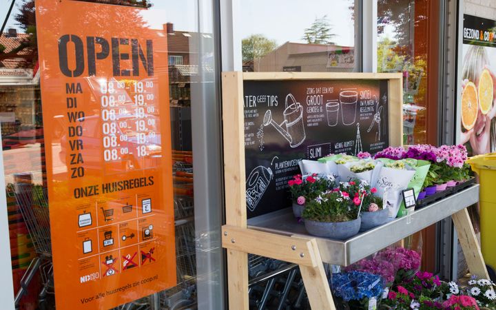 Op de foto is een bord met de openingstijden van een winkel te zien. Deze winkel is op zondag gesloten.