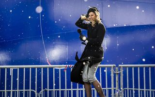 Koningin Máxima, in donkere outfit. Op de achtergrond een schip.