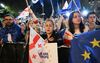 Betogers zwaaien met Georgische en Europese vlaggen tijdens een demonstratie buiten het parlementsgebouw in Tbilisi, Georgië. Aanleiding voor de protesten is een wetsvoorstel over een buitenlandse-agentenwet. beeld AFP, Vano Shlamov 