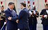 De Chinese leider Xi Jinping en de Franse president Emmanuel Macron groeten elkaar maandag bij het Élyséepaleis in Parijs. beeld AFP, Ludovic Marin