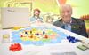 Bedenker Klaus Teuber van het bordspel Catan poseert in 2020 op de International Toy Fair in Neurenberg bij zijn creatie. beeld EPA, Philipp Guelland