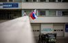 Een man zwaait met de Slowaakse vlag bij het ziekenhuis waar de Slowaakse premier Robert Fico wordt behandeld. De premier werd op 15 mei neergeschoten na een bijeenkomst in de stad Handlová. beeld EPA, Martin Divisek