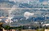 De Noord-Israëlische stad Kiryat Shmona, tegen de grens met Libanon aan, is inmiddels meermalen bestookt door raketten van Hezbollah. Deze foto dateert van 5 mei: rook stijgt op na raketinslagen. beeld AFP, Jalaa Marey