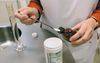 Een apotheker doet vitamine C in een potje. beeld Henk Visscher