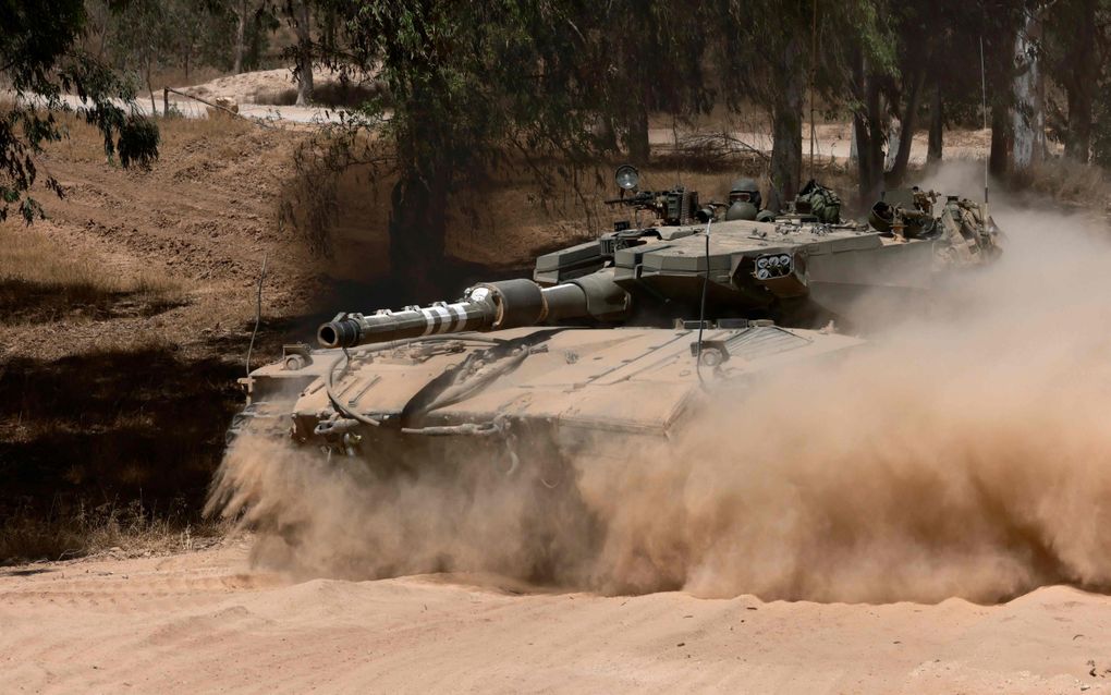 Een Israëlische tank manoeuvreert aan de zuidelijke grens met de Gazastrook. Volgens het leger worden de operaties in Gaza afgeschaald. beeld AFP, Menahem Kahana