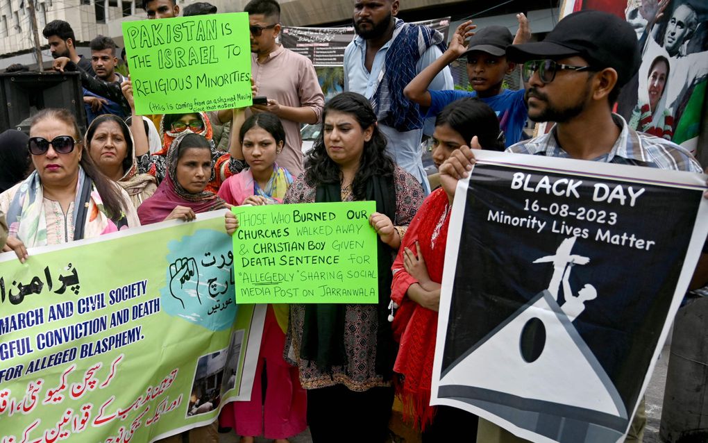 „Degenen die onze kerken in brand staken gingen vrijuit en een christelijke jongen krijgt de doodstraf voor het vermeend delen van een post op sociale media”, staat er op het vel papier dat deze demonstrante in Karachi voor zich houdt. De foto laat overigens ook zien hoe de demonstranten tegen Israël aankijken: ”Pakistan is het Israël voor religieuze minderheden”, staat er op de poster achter haar. beeld AFP, Rizwan Tabassum