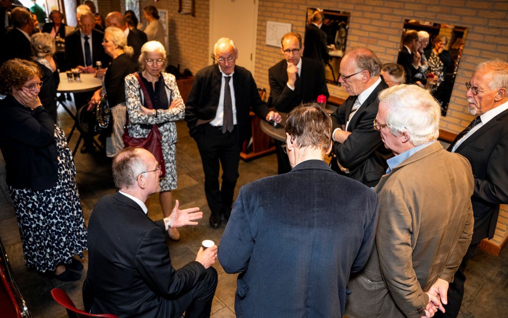 Ds. P. de Vries (zittend) in gesprek met een aantal bezoekers tijdens de ontmoetingsdag in Boven-Hardinxveld. beeld Cees van der Wal