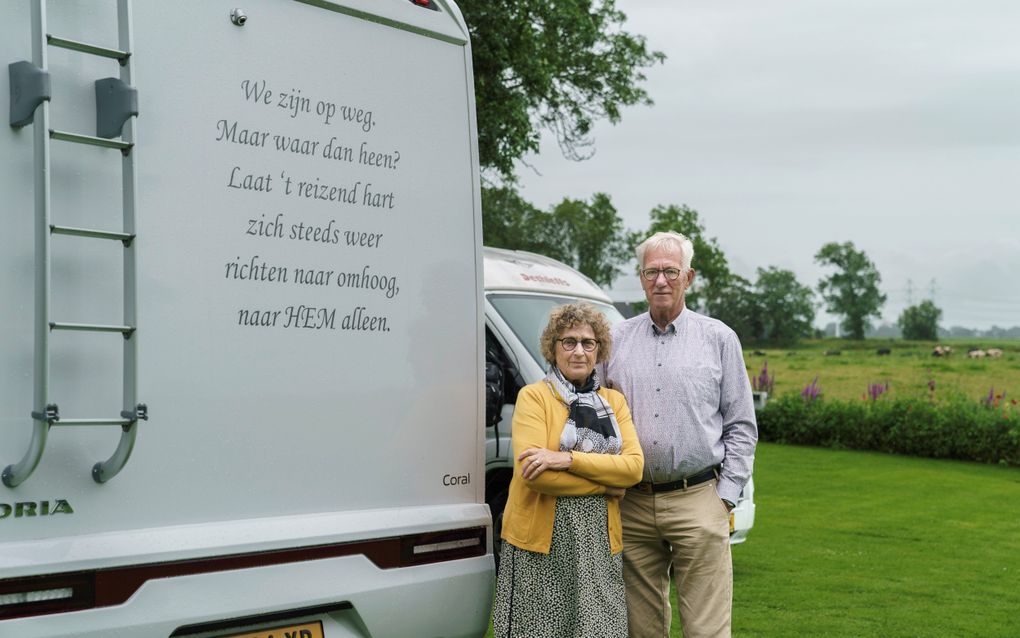 Ko en Suzan Wisse bij hun camper, waarop een Bijbelse boodschap staat. beeld Reyer Boxem