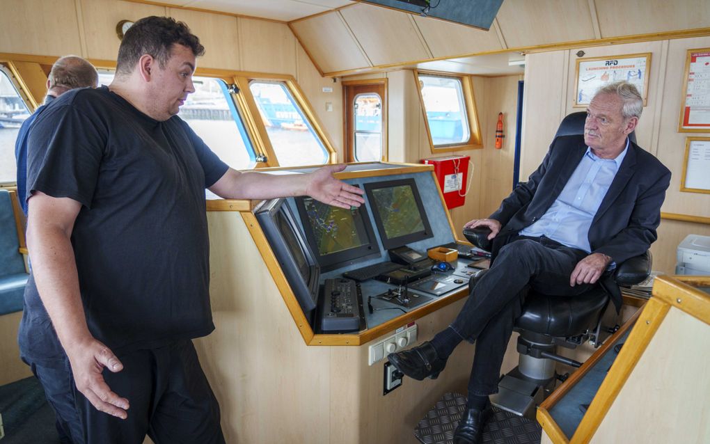 Schipper Jan de Boer (l.) lucht op de brug van de OD-1 zijn hart tegenover staatssecretaris Jean Rummenie (Visserij). beeld ANP, Lex van Lieshout