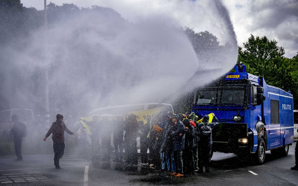 Demonstranten van Extinction Rebellion (XR) blokkeren de oprit van A12 en de politie gebruikt het waterkanon. Het protest op de A12 is gericht tegen fossiele subsidies. Tegelijk met de blokkade zou XR een protest op het Malieveld houden, maar die is afgelast vanwege het slechte weer. beeld ANP, Robin Utrecht 