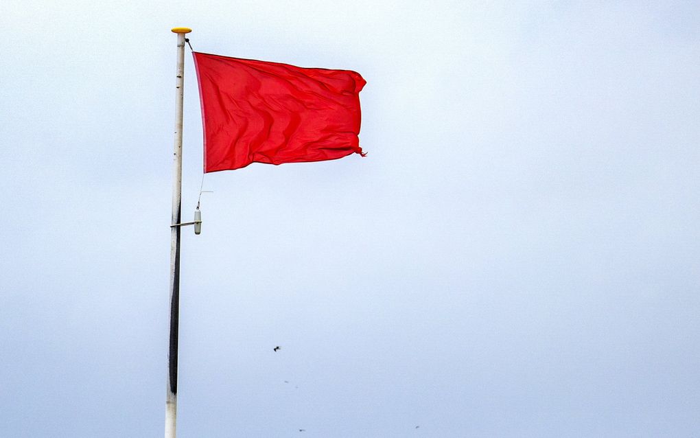 Een rode vlag aan de kust van Wijk aan Zee. beeld ANP, Ramon van Flymen