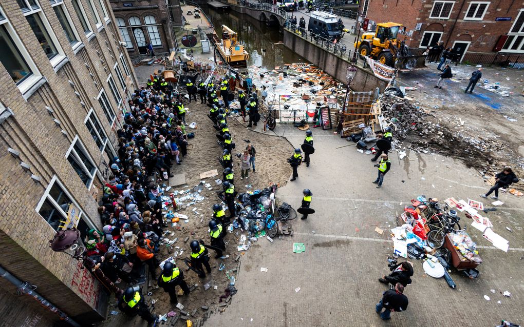 Demonstranten omsingeld door de politie bij een gebouw van de Universiteit van Amsterdam (UvA) op het Binnengasthuisterrein, op 8 mei in Amsterdam. beeld ANP, Ramon van Flymen