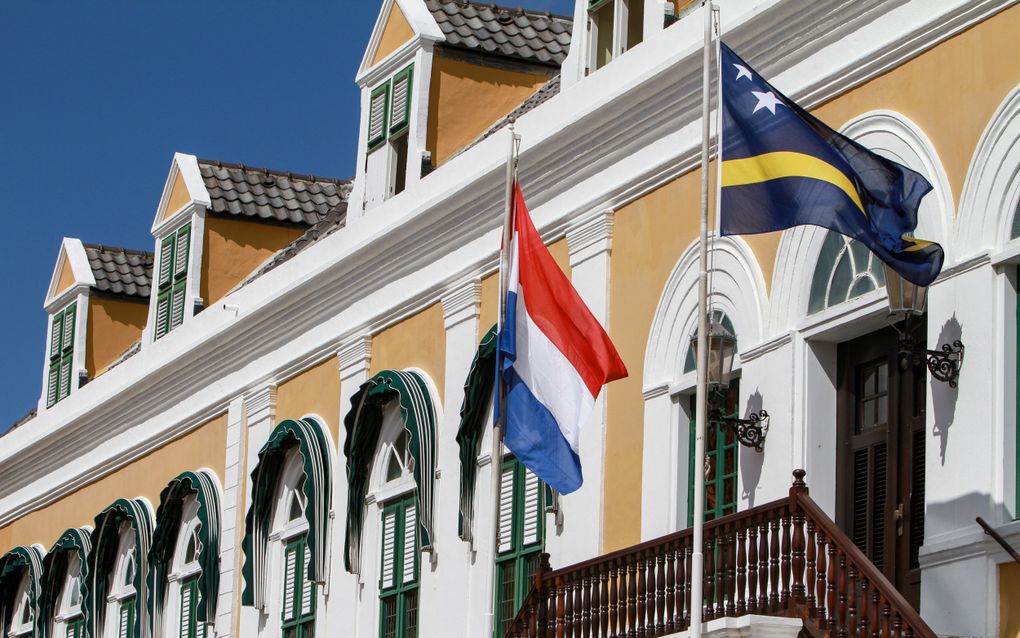 De vlaggen van Nederland en Curaçao op het parlementsgebouw in Willemstad. beeld ANP, Price Victor