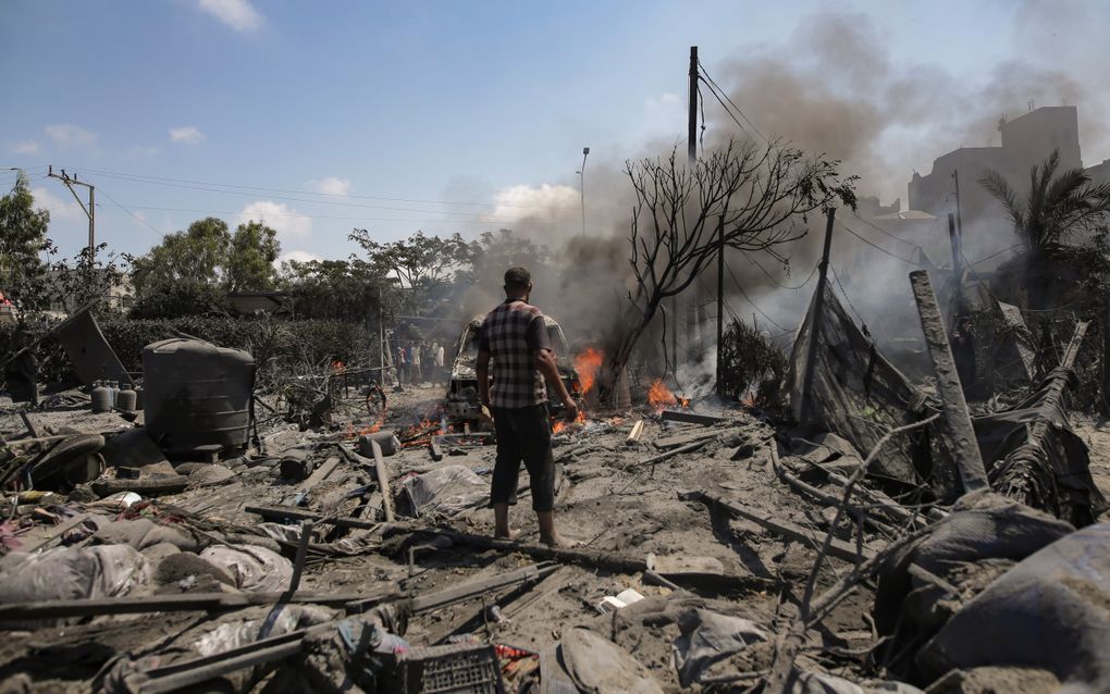 Een Palestijnse man inspecteert zaterdag het gebied in Khan Younis waar Israël een luchtaanval op uitvoerde. beeld EPA, Haitham Imad