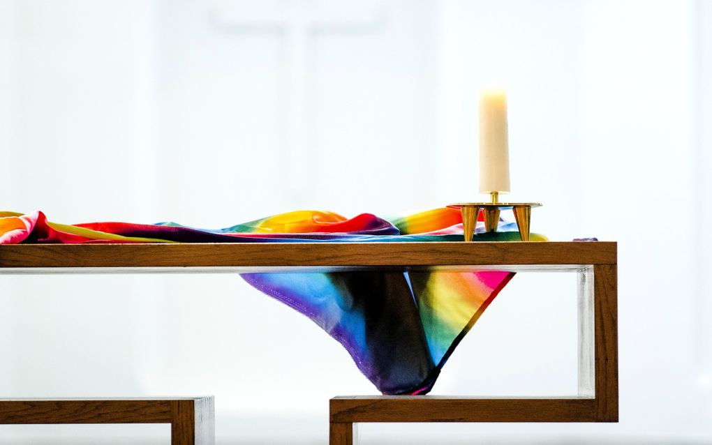 „Iedereen mag tot Christus komen zoals hij of zij is, maar vervolgens kun je als gelovige niet blijven die je bent. Je wordt dagelijks vernieuwd naar Gods heilige wil.” Foto: een regenboogvlag ligt op tafel in de Utrechtse Janskerk. beeld ANP, Remko de Waal