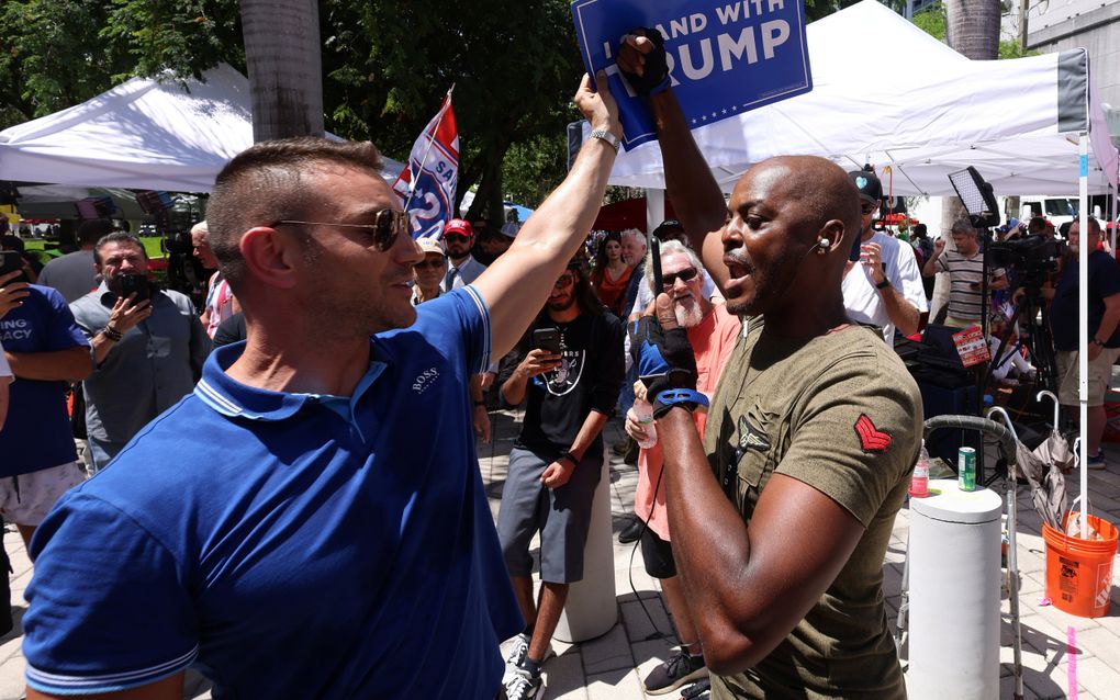 Aanhangers en tegenstanders van Donald Trump staan tegenover elkaar buiten de rechtbank waar een zaak tegen de oud-president dient. beeld EPA, Justin Lane